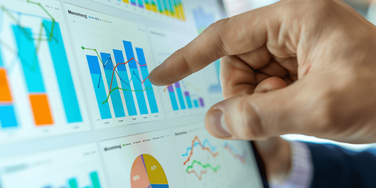 Hand pointing at a dashboard of fundraising data charts and graphs, representing automated CRM data imports with Charity Automator Data Flow.
